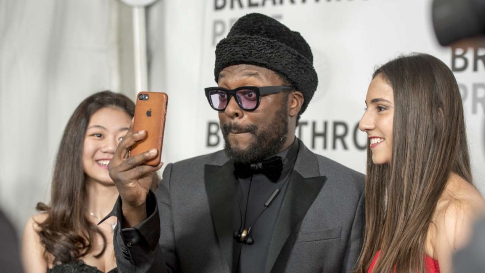 El rapero Will.i.am se toma una selfe con los ganadores Deanna See y Antonella Masini detrás del escenario de la Breakthrough Junior Challenge en el Centro de Investigación Ames de la NASA en Mountain View, California (Foto de Peter Barreras / Invision / AP )