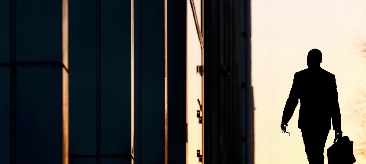 A worker arrives at his office in the Canary Wharf business district in London February 26, 2014.