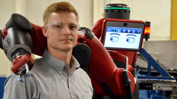 Mechanical engineer Jesse Rochelle works with a Robot called Baxter which automates production at the Stenner Pumps factory Thursday April 21, 2016 in Jacksonville, Florida.