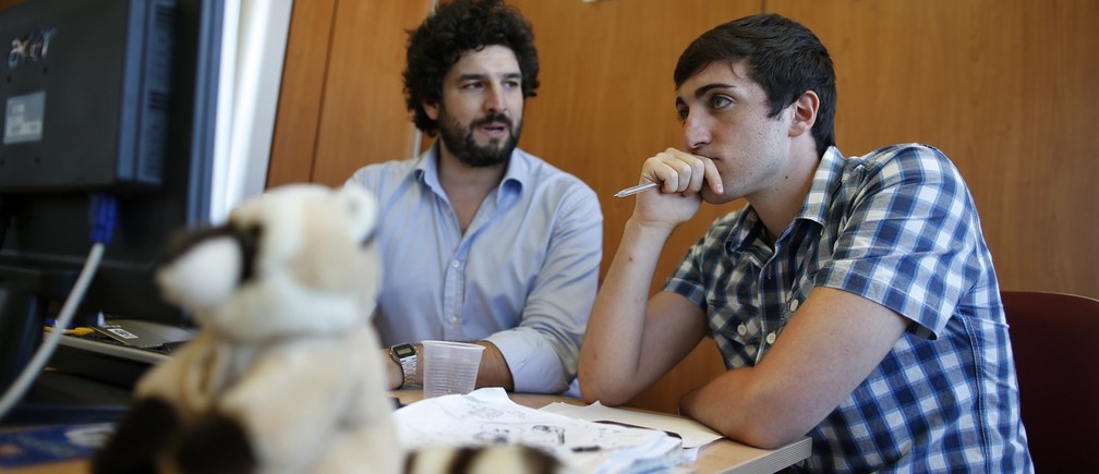 Matteo Achilli (R) works with one of his assistants in his office in Formello, north of Rome July 25, 2013. Achilli, dubbed the Italian Zuckerberg by Panorama Economy, is the 21-year-old founder of Egomnia, a social network created to match companies looking to hire graduate job seekers. According to Achilli, Egomnia, which was founded in February 2012, has around 100,000 users, about 600 multinational companies in Italy as clients and a 2013 sales volume of about 500,000 euros. Picture taken July 25, 2013